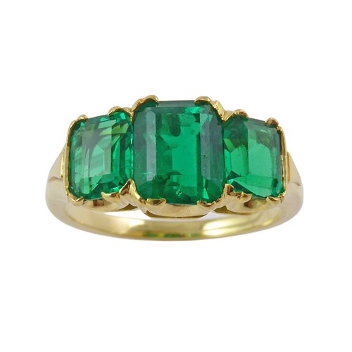 Graduated three stone emerald ring, with cushion step-cut Colombian emeralds, the central emerald of approximately 1.25ct,